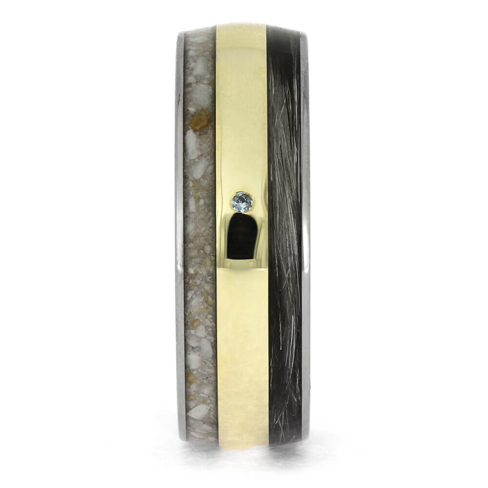 Gold and black ring with a central gemstone on a white background