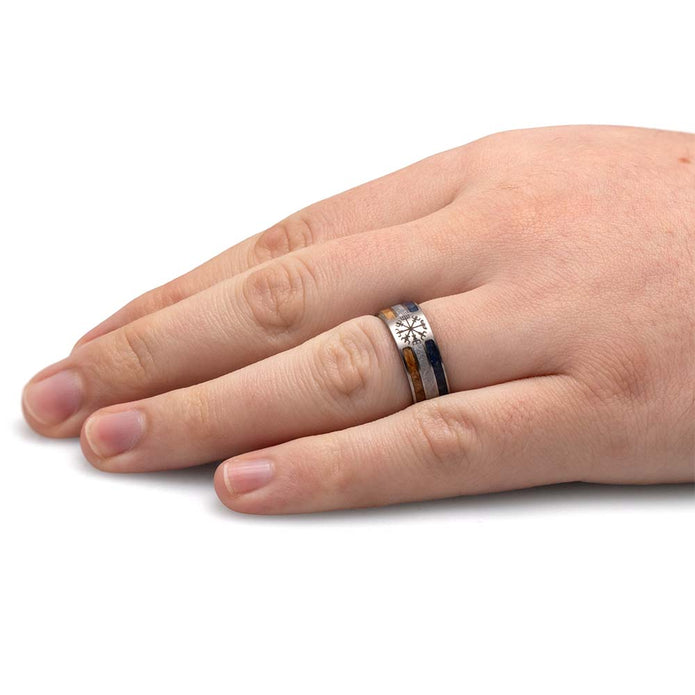 Hand wearing a silver ring with a star design on a white background