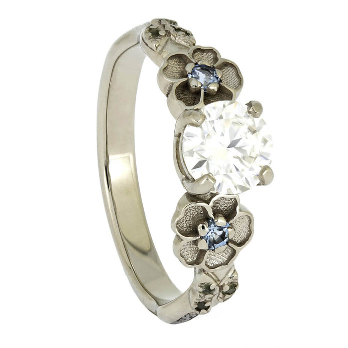 Silver ring with floral designs and embedded diamonds on a white background