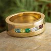 Gold ring with colorful gemstones on a stone surface