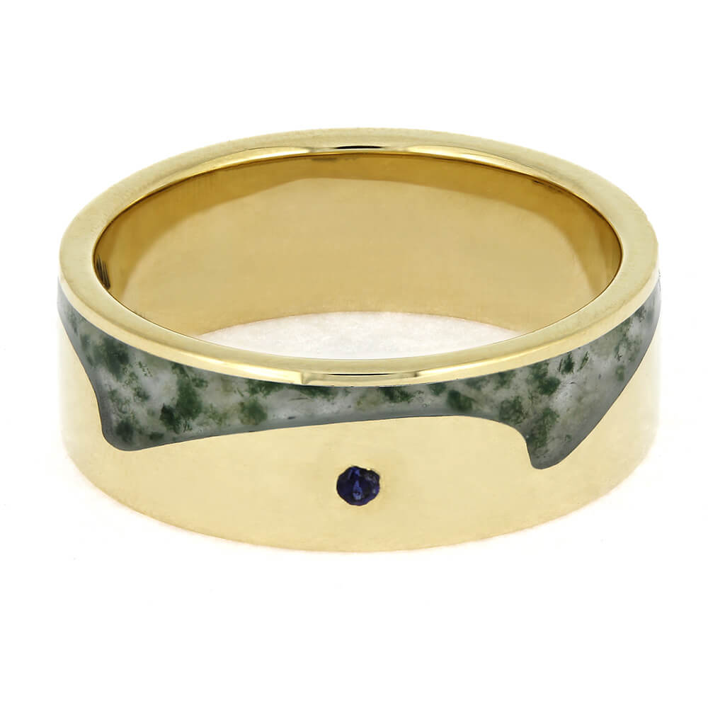 Gold ring with green stone and purple gemstone on a white background