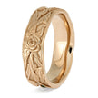 Rose gold ring with floral engraving on a white background