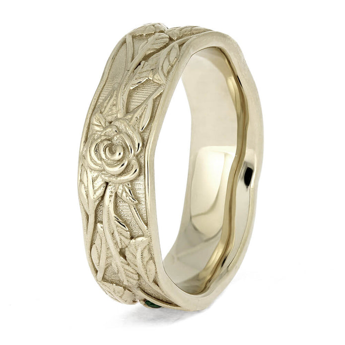 Gold ring with floral engraving on a white background