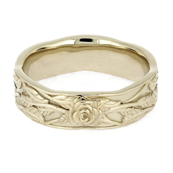 Gold ring with floral engraving on a white background