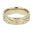 Gold ring with floral engraving on a white background