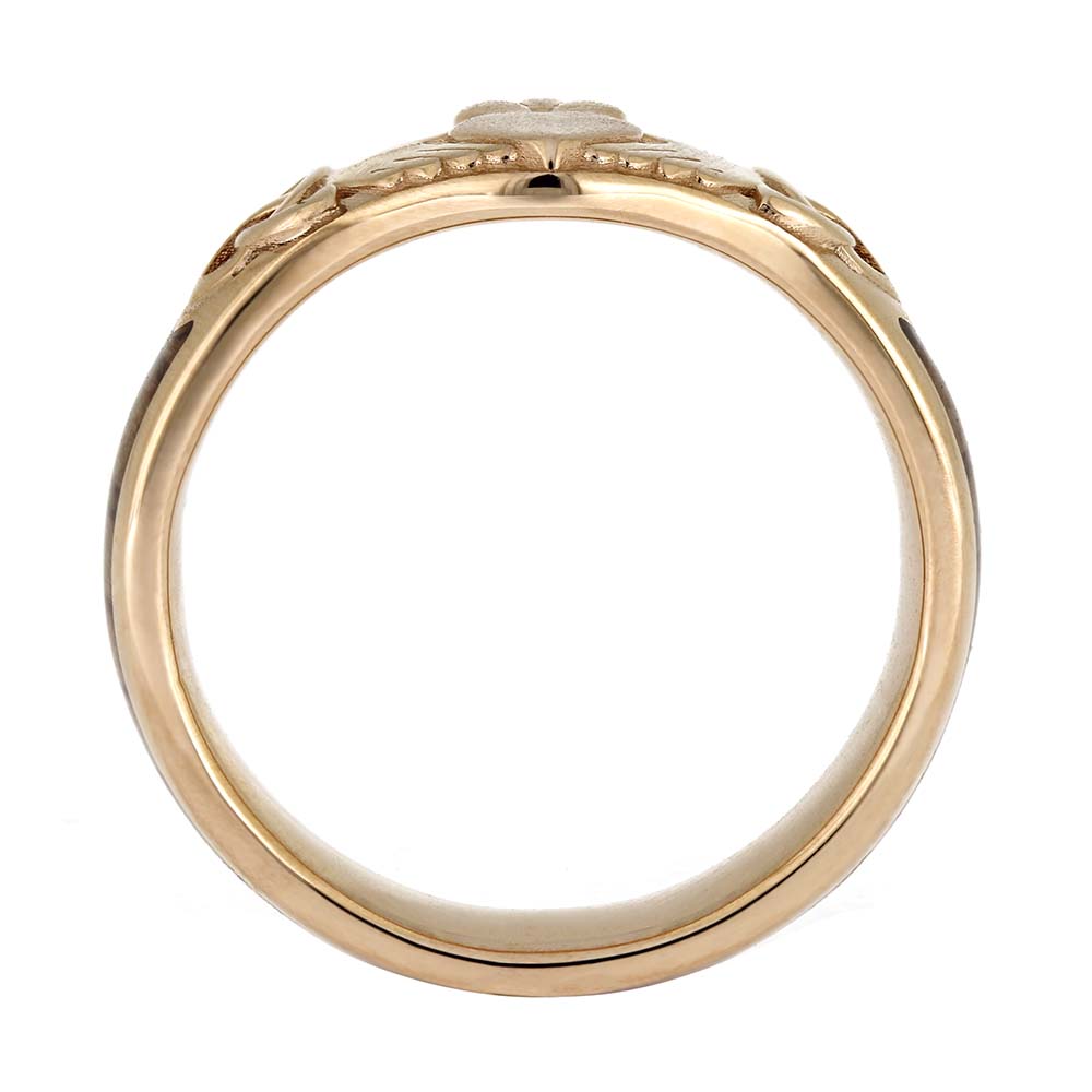 Gold ring with intricate design on a white background