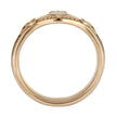 Gold ring with intricate design on a white background