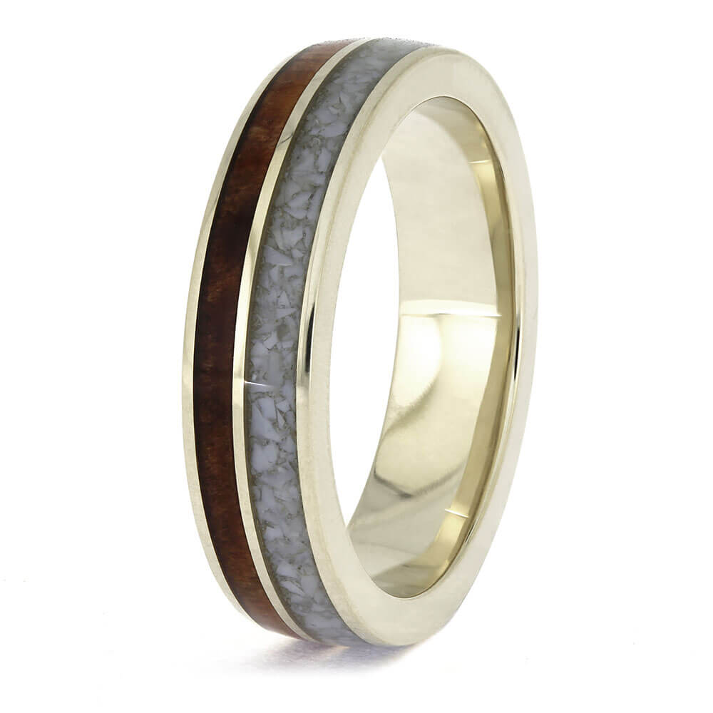 Gold ring with a wooden and gray inlay on a white background
