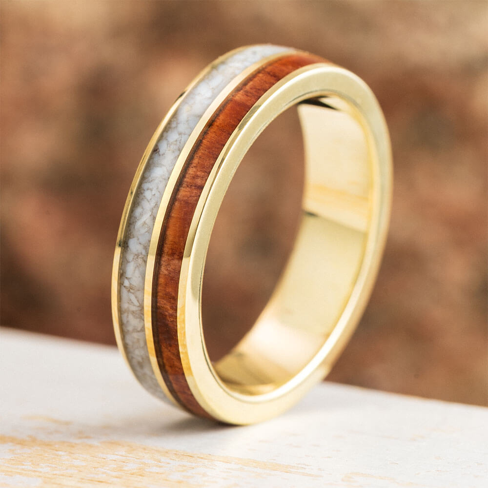 Gold ring with wooden inlay on a wooden surface