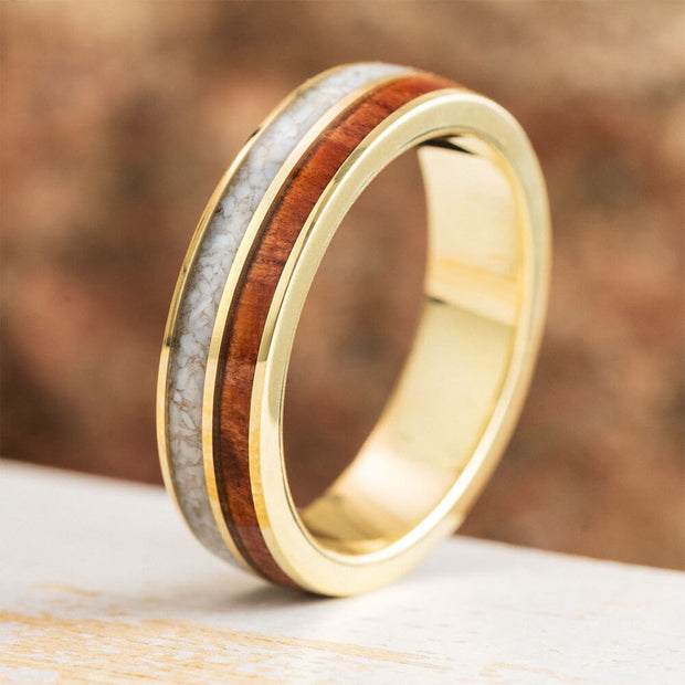 Gold ring with wooden inlay on a wooden surface