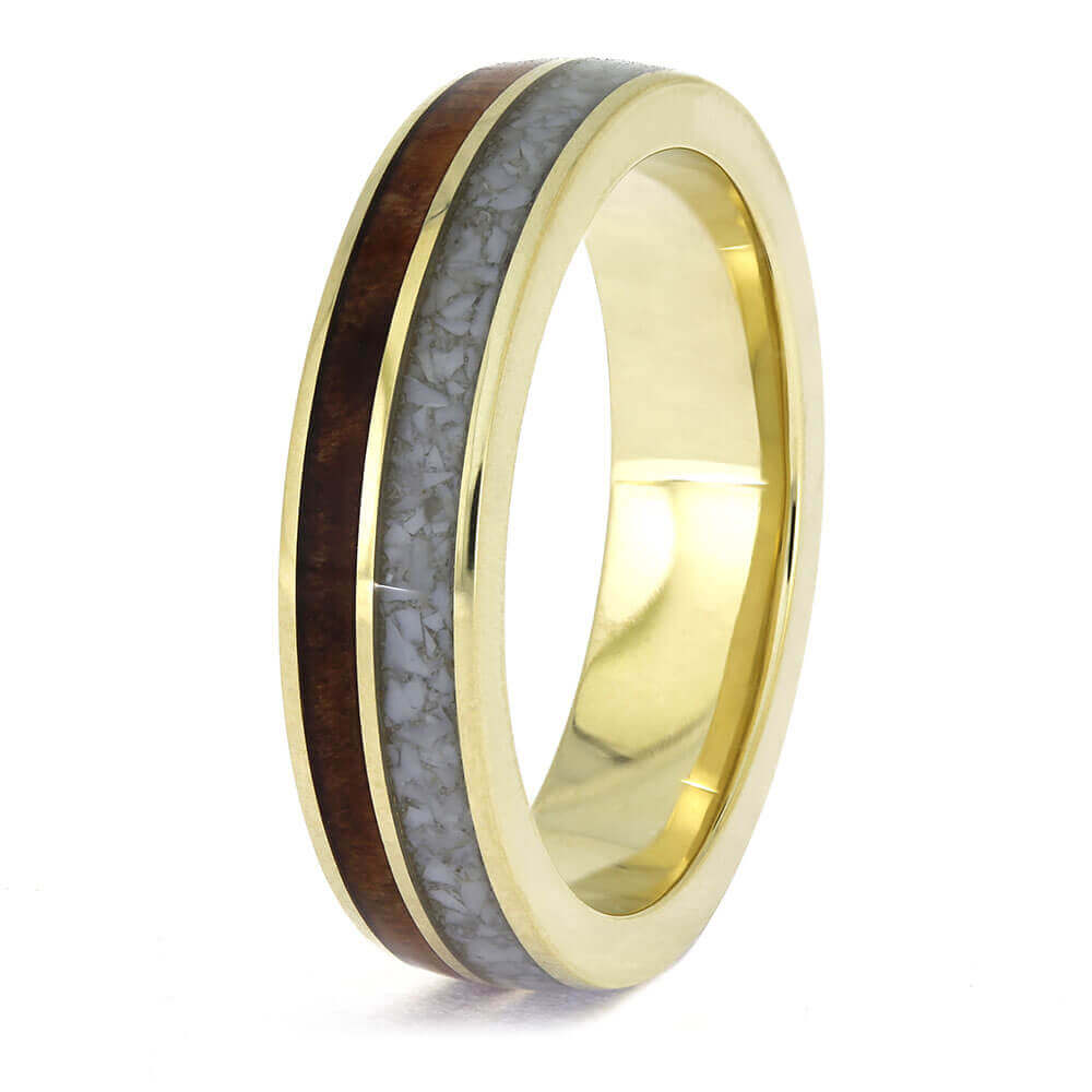 Gold ring with a wooden and gray inlay on a white background