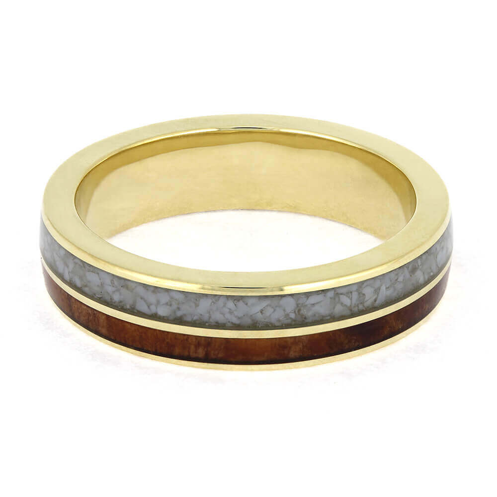 Gold ring with a gray and brown inlay on a white background