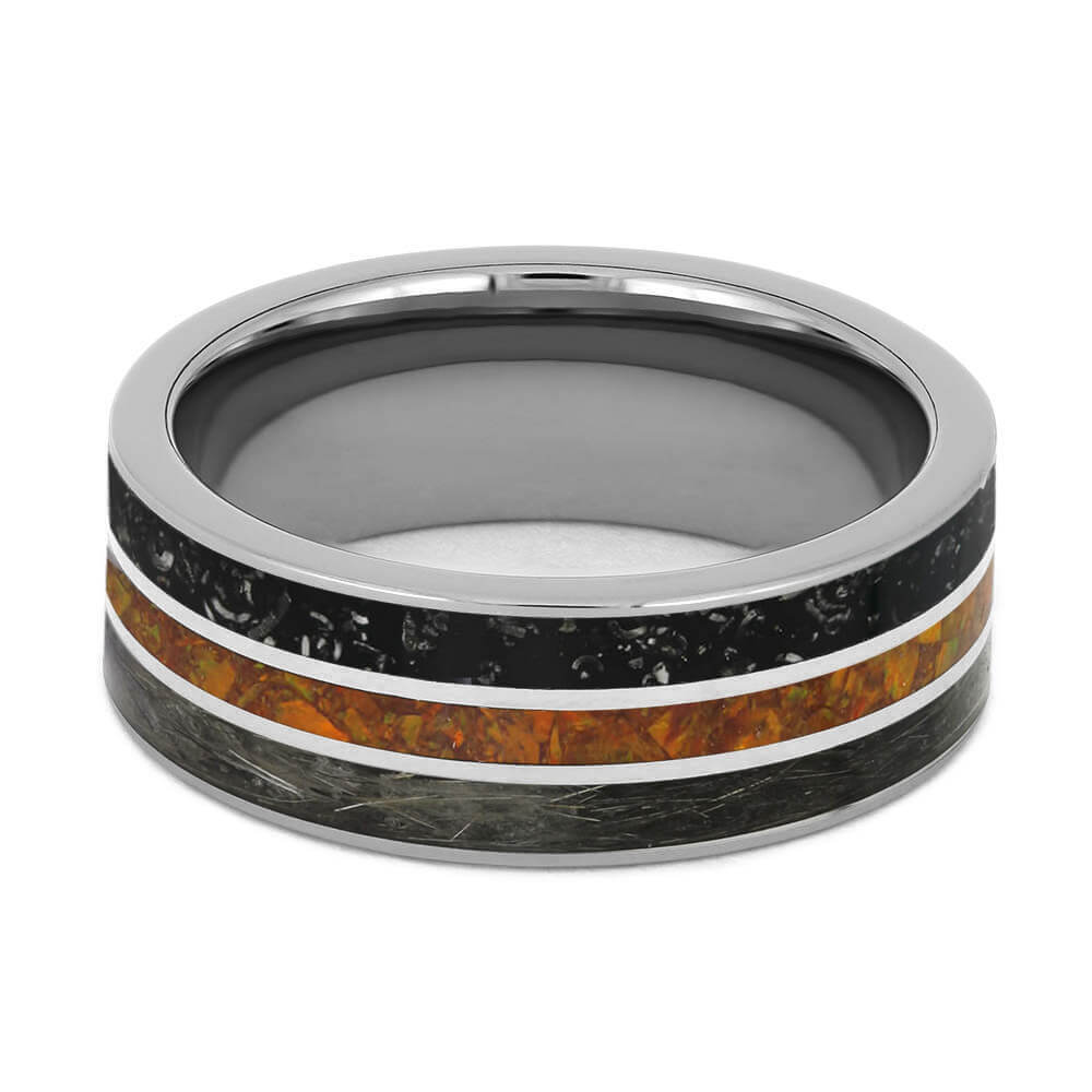 Silver ring with black and orange inlay on a white background