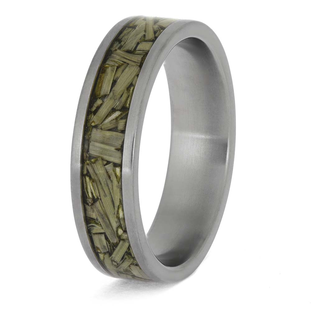 Silver ring with embedded green material on a white background