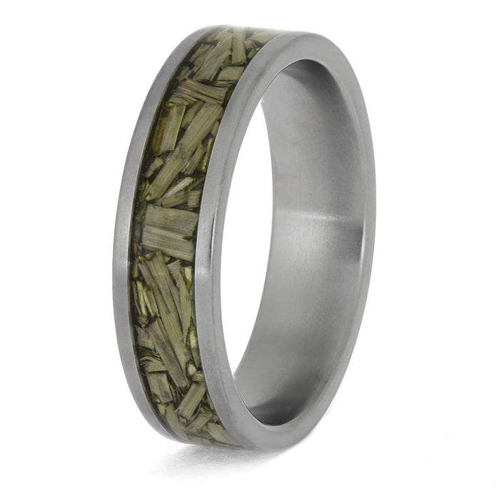 Silver ring with embedded green material on a white background
