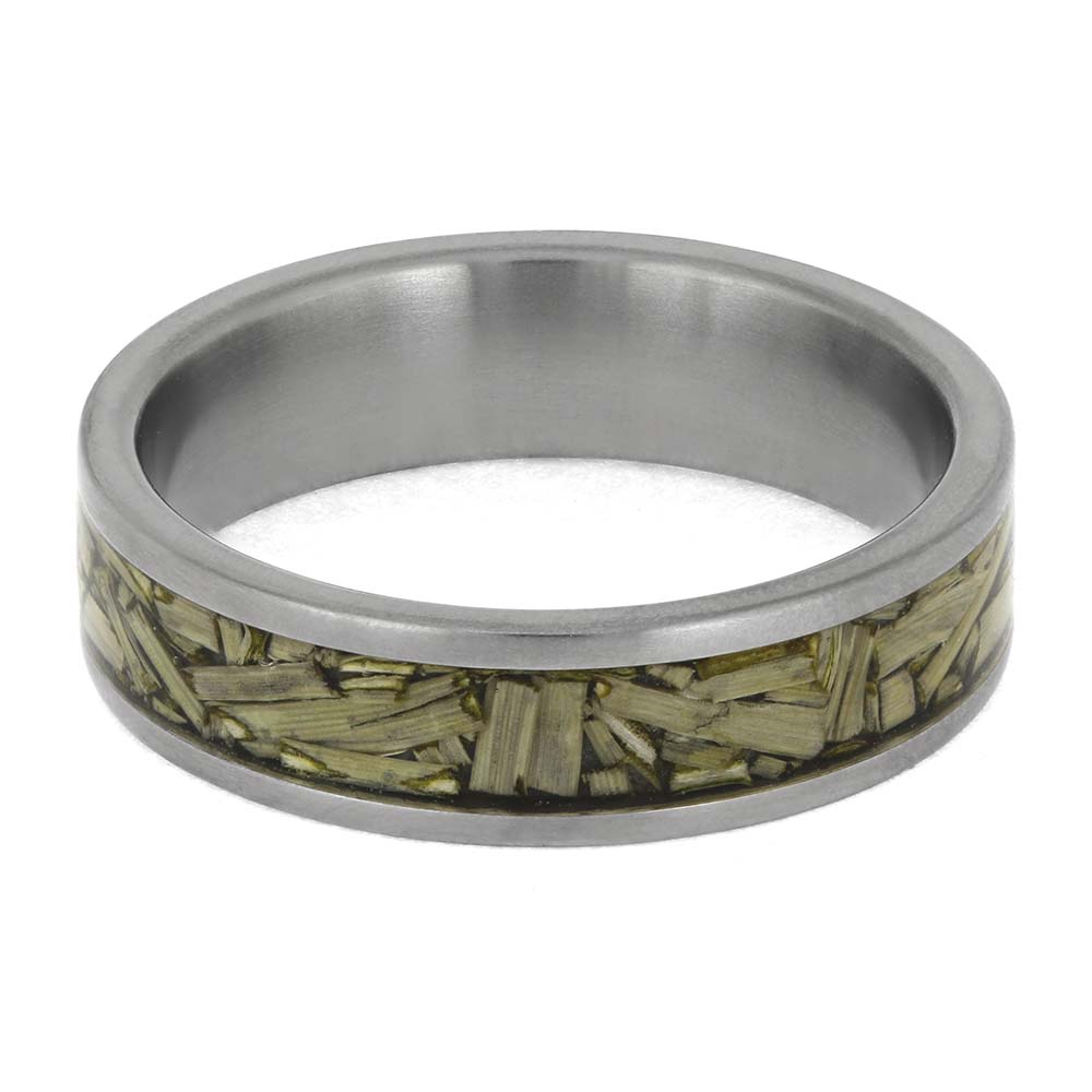 Silver ring with a green leaf-like inlay on a white background