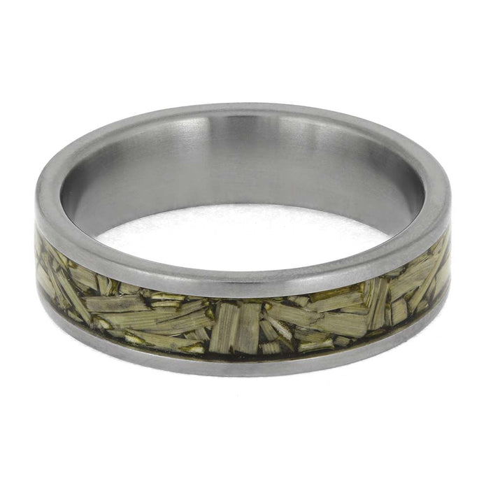Silver ring with a green leaf-like inlay on a white background