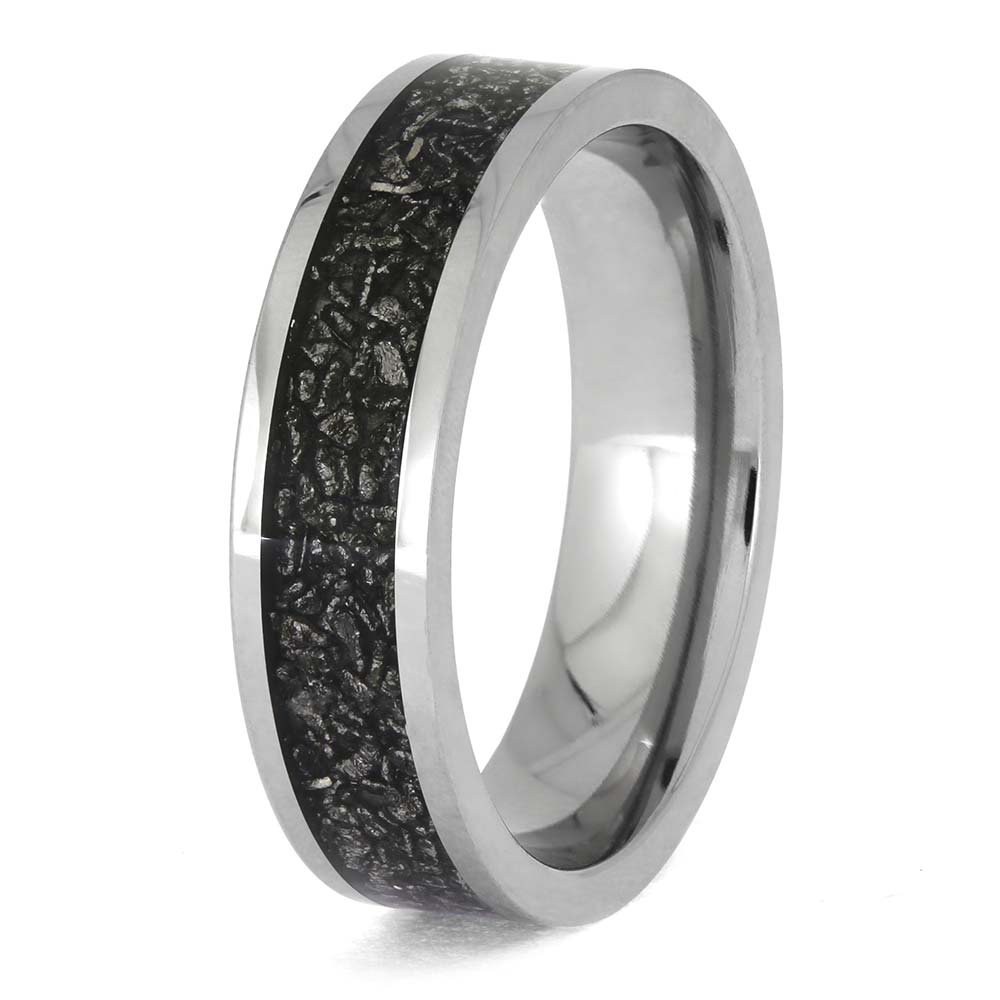 Silver ring with black textured inlay on a white background