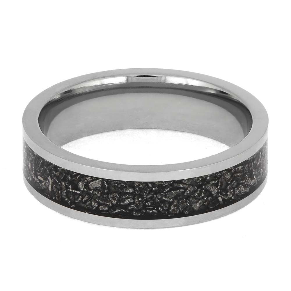Silver ring with a black textured band on a white background