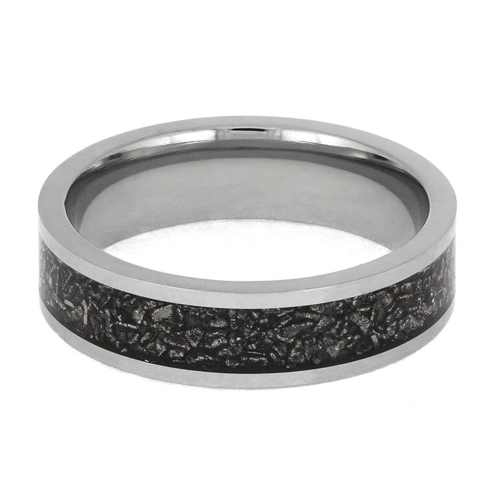 Silver ring with a black textured band on a white background