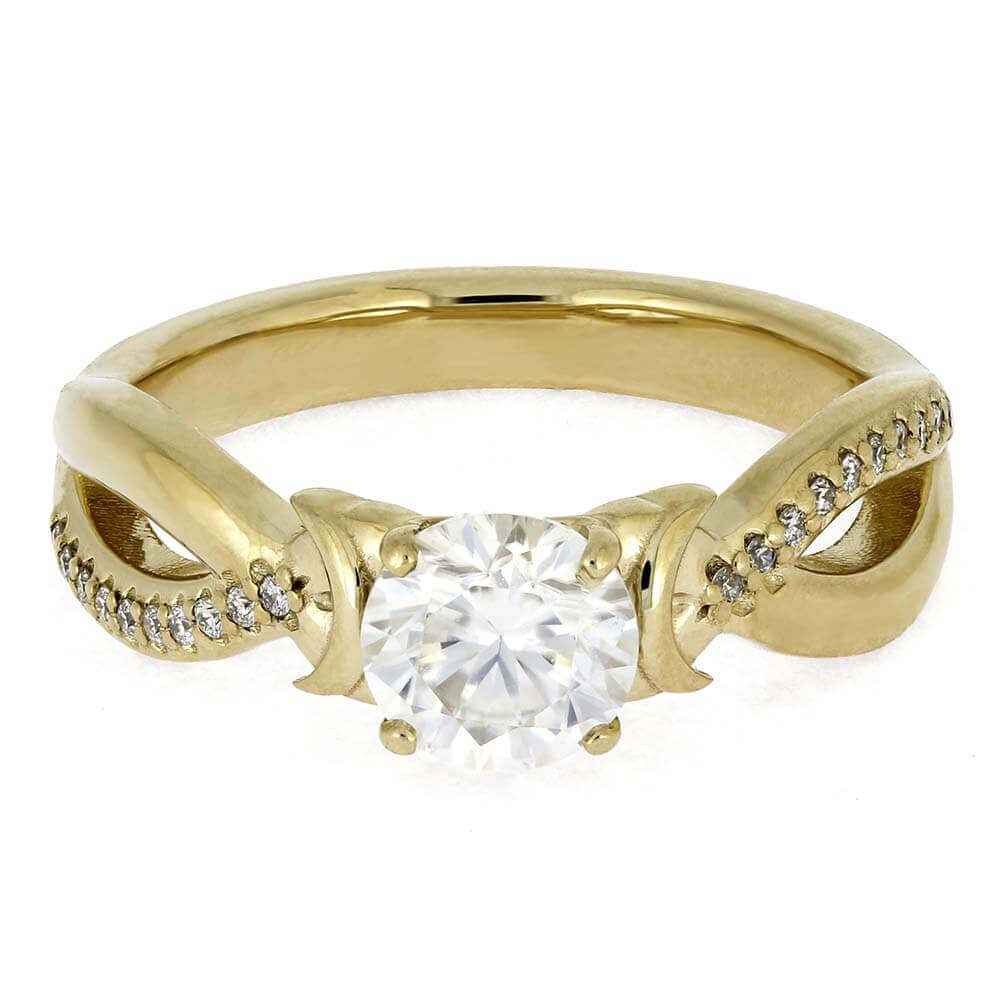 Gold ring with a large diamond and smaller diamonds on the band against a white background