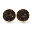 Round earrings with gold rim and dark textured center on a white background