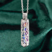 Silver pendant with colorful interior on a green fabric background