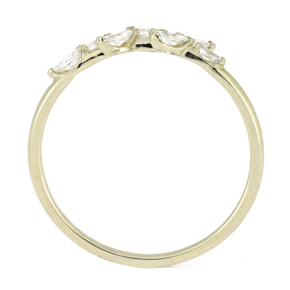 Gold ring with heart-shaped diamonds on a white background