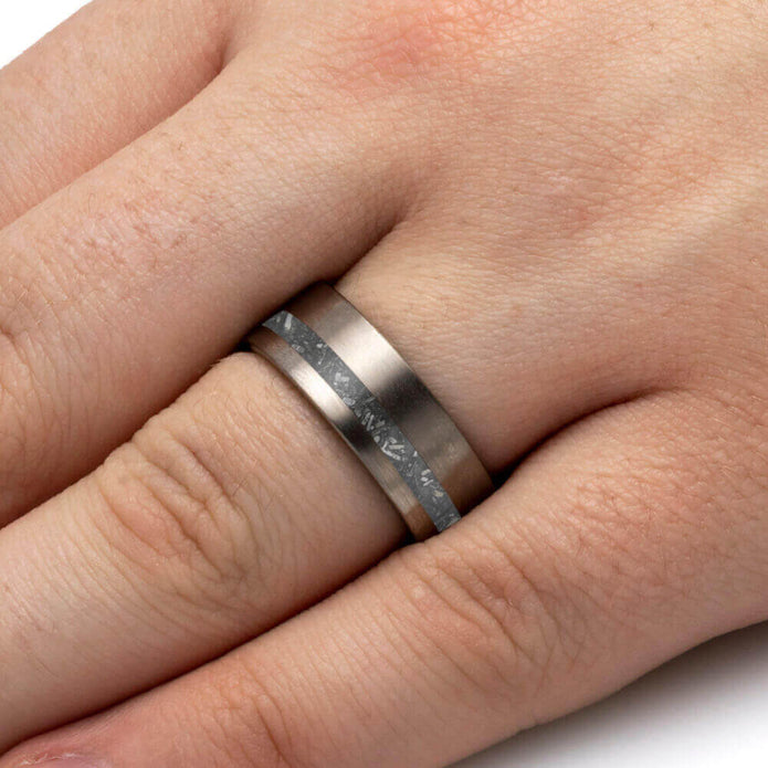 Silver ring with a textured band on a person's finger