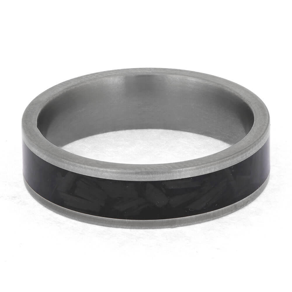 Silver ring with a black carbon fiber inlay on a white background