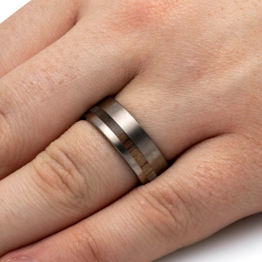 Silver ring with wooden inlay on a finger