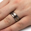 Silver ring with wooden inlay on a finger