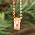 Rose gold urn necklace with gem, close-up view