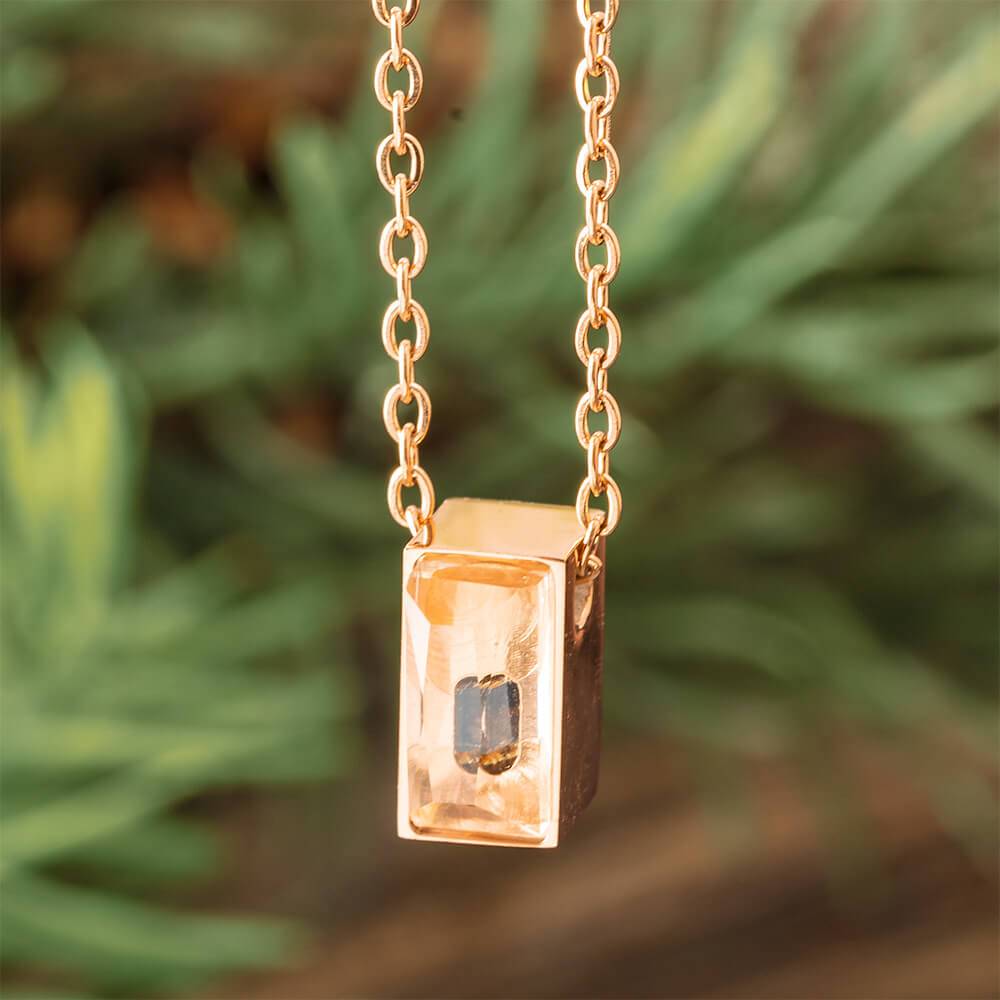 Rose gold urn necklace with gem, close-up view