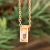 Rose gold urn necklace with gem, close-up view