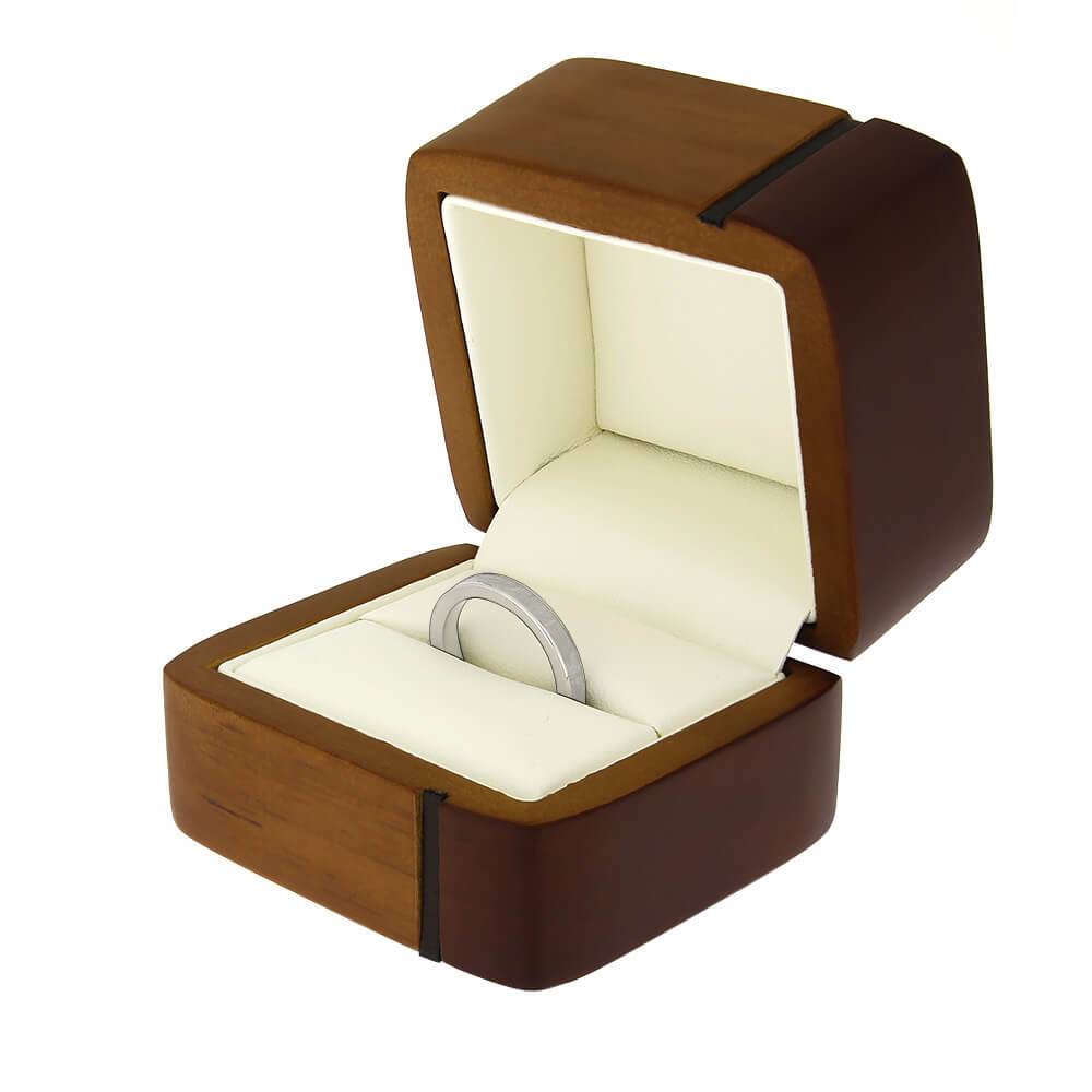 Open wood ring box displaying a silver ring