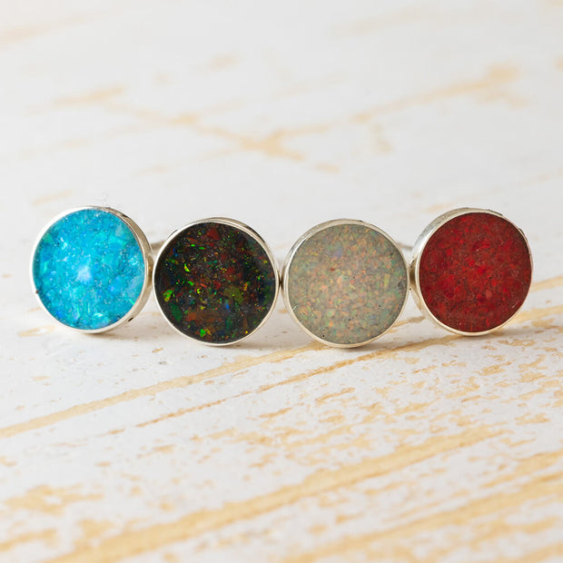 Set of four radiant opal stud earrings in blue, black, white, and red hues with sterling silver settings. Add color to your look with opal studs.