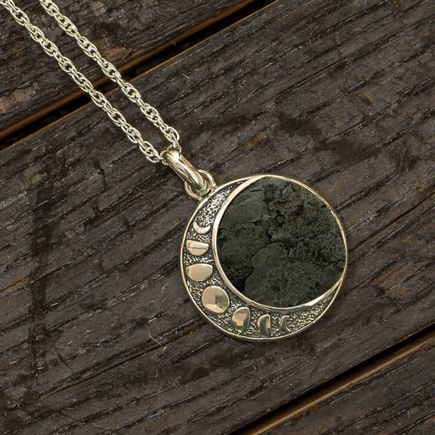Moon phase necklace with meteorite on wooden background
