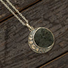 Moon phase necklace with meteorite on wooden background