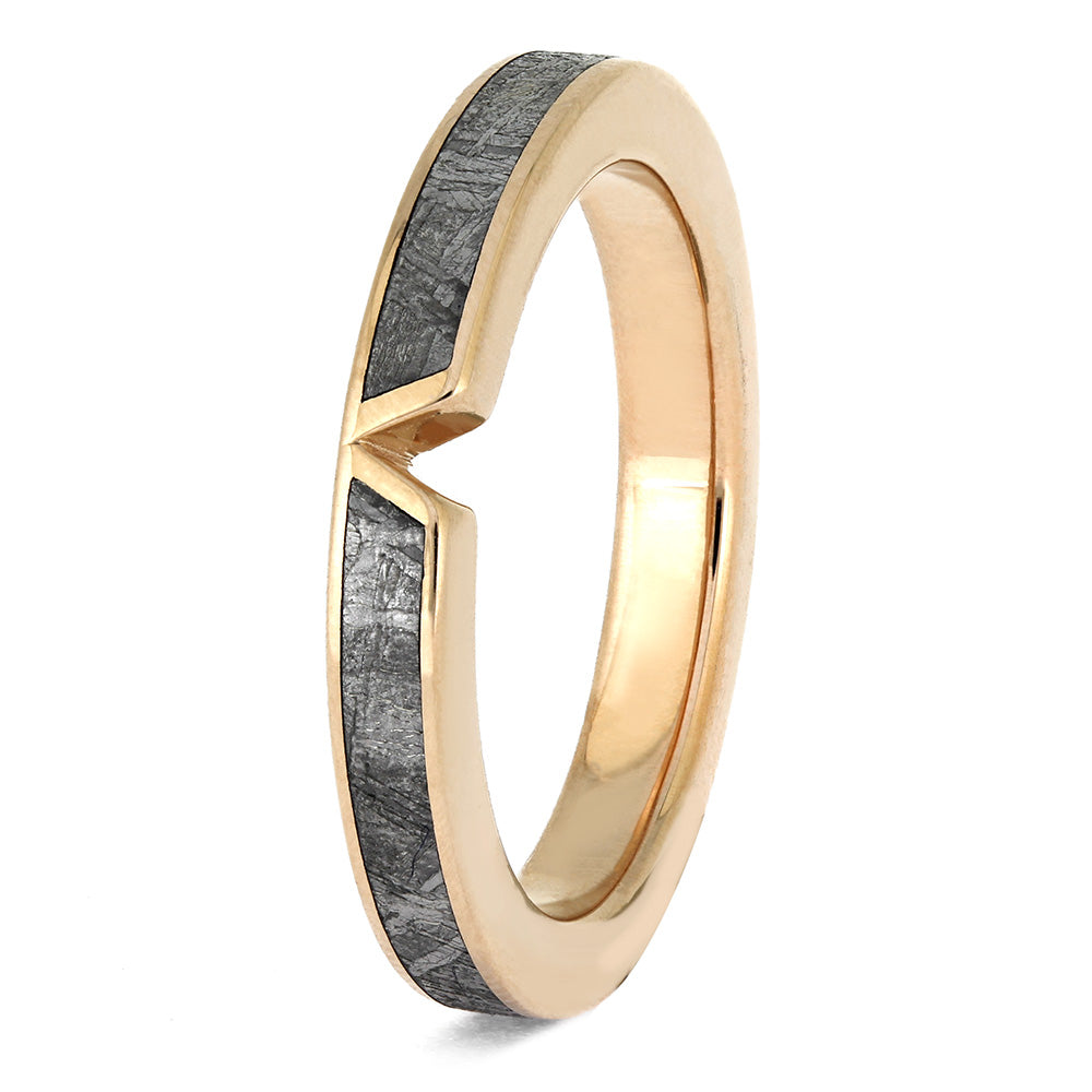 Gold ring with a textured black band on a white background