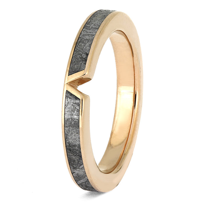 Gold ring with a textured black band on a white background