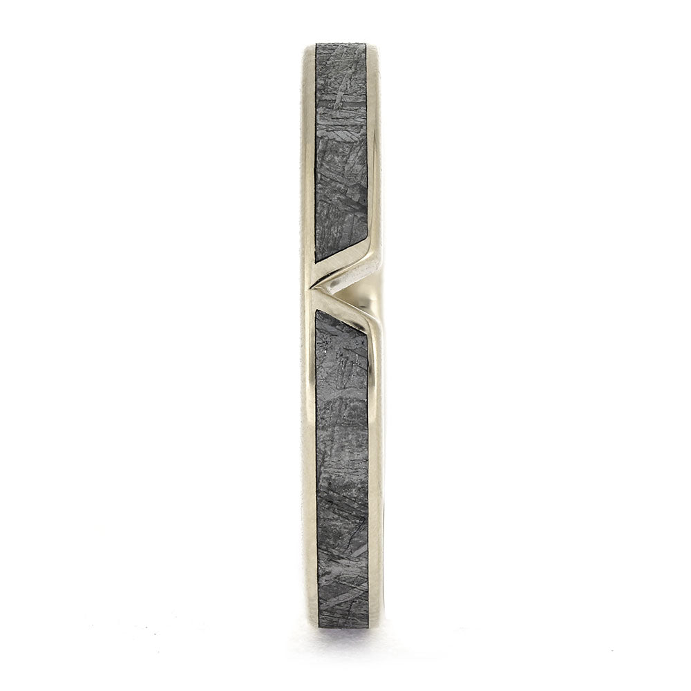 Gold ring with a textured black band on a white background