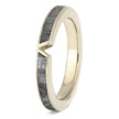 Gold ring with a textured black band on a white background