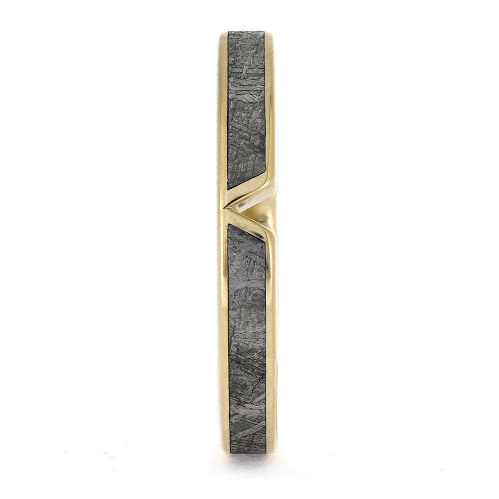 Gold ring with a central black stone on a white background
