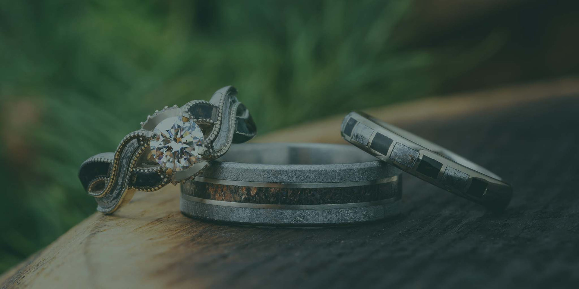 Two silver rings on a wooden surface with a blurred green background