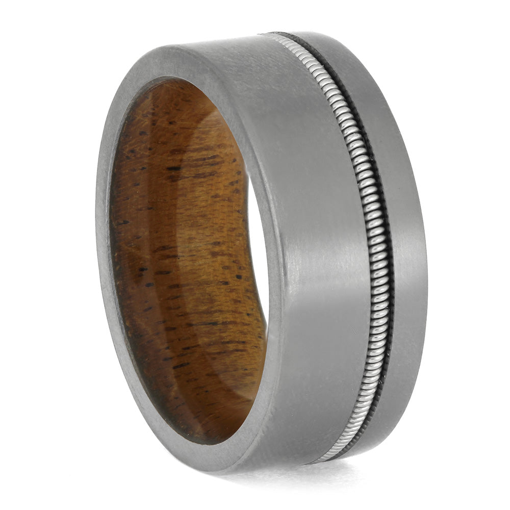 Men's Guitar String Titanium Ring with flat profile and mahogany wood sleeve, combining rugged titanium with musical detail for a unique wedding band.