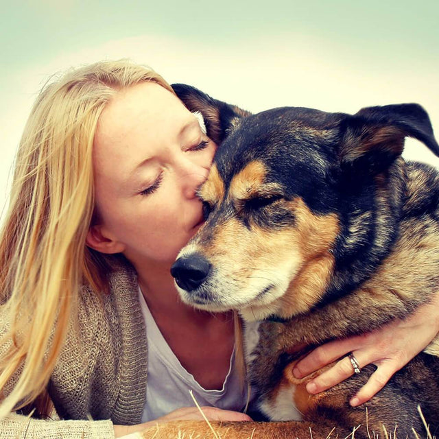 woman kissing her dog