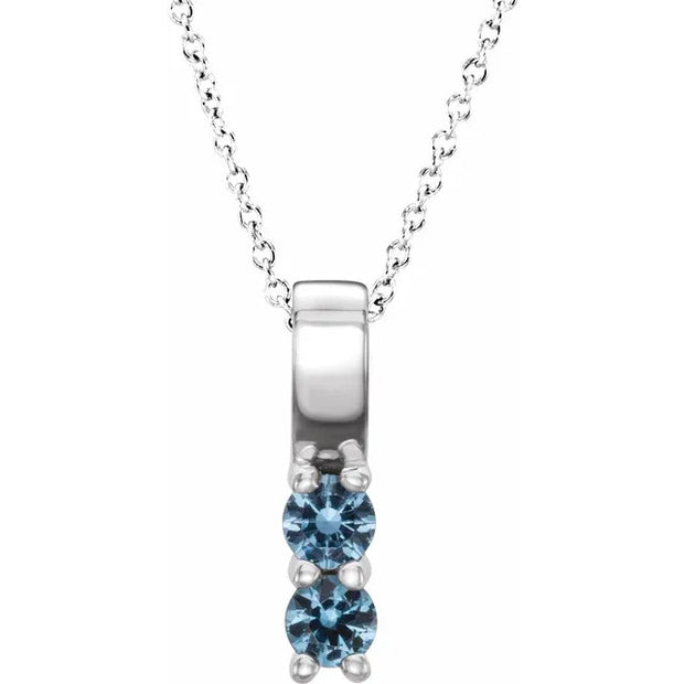 Silver necklace with a blue gemstone pendant on a white background