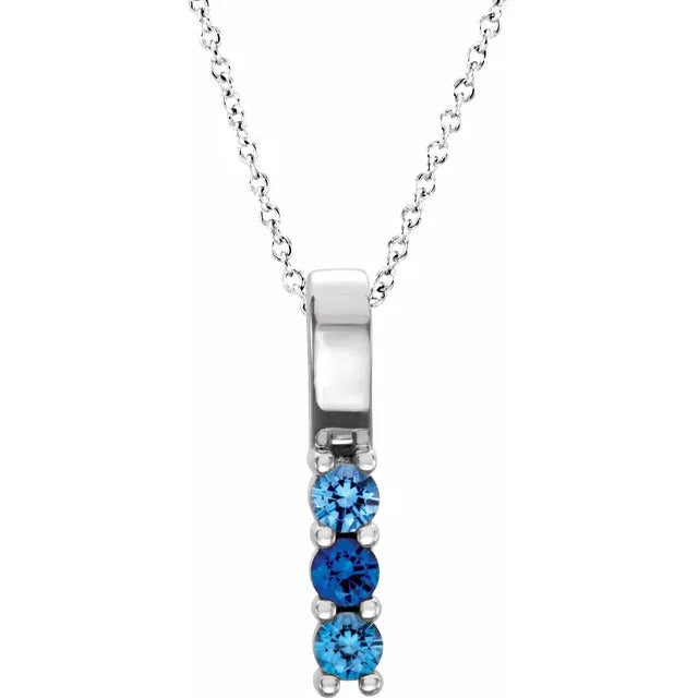 Silver necklace with blue gemstones on a white background