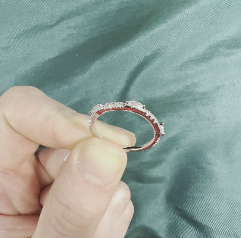 Hand holding diamond half eternity band with marquise cuts